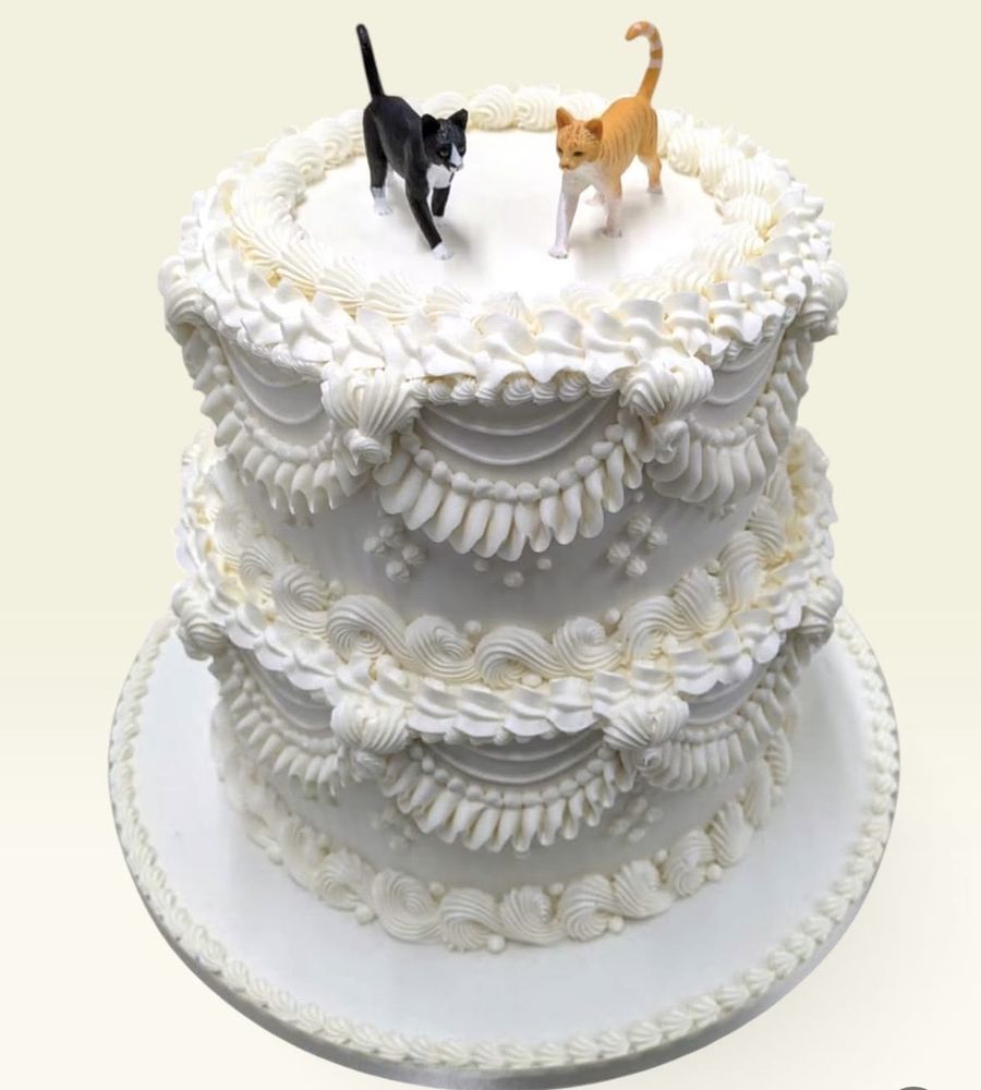 Two-tier white Lambeth cake with cat toppers
