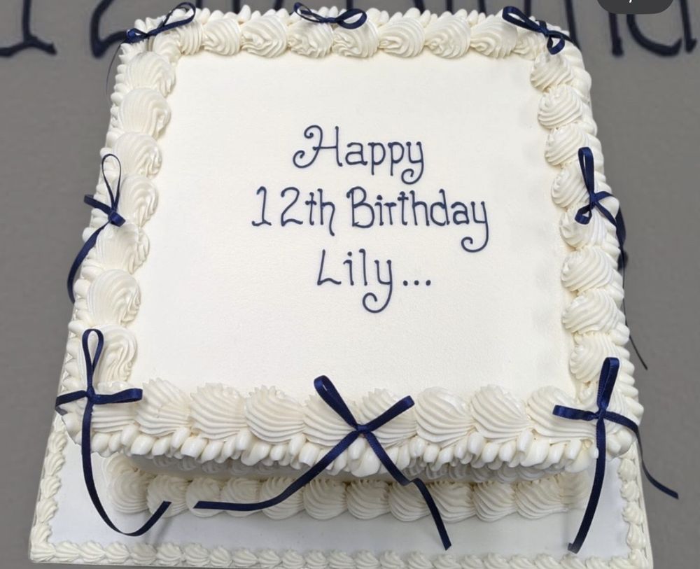 Square white Lambeth birthday cake with navy bows